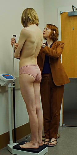 Emma Stone measuring Hunter Schafers plot from Kinds of Kindness (2024)'